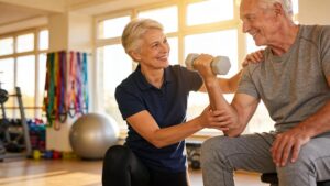 Personal trainer conducting a fitness session with a senior, focusing on mobility and strength improvement