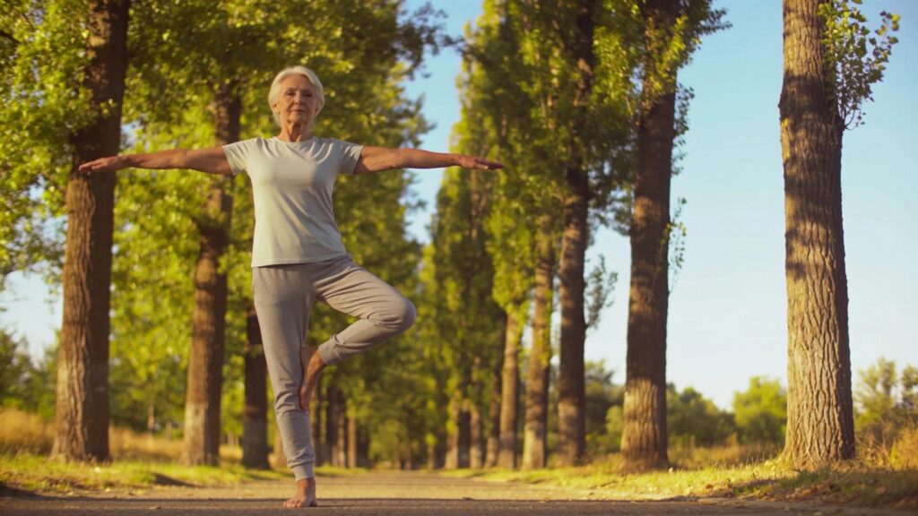 Senior engaging in low-impact exercises outdoors, showcasing balance and flexibility for health and wellness